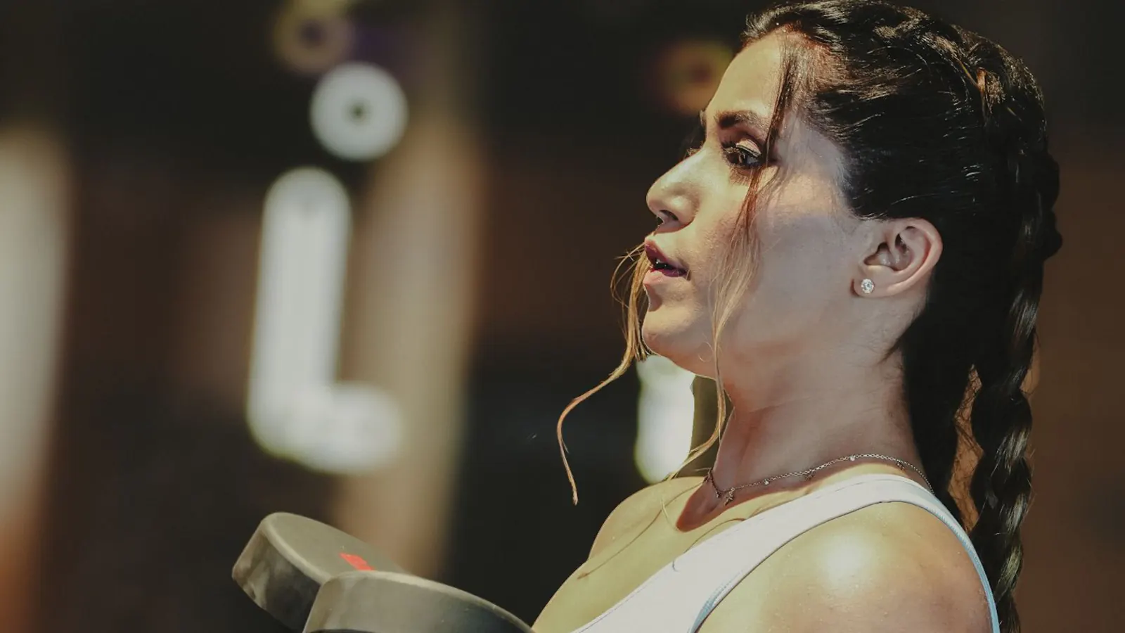 Woman training with dumbbells in a gym