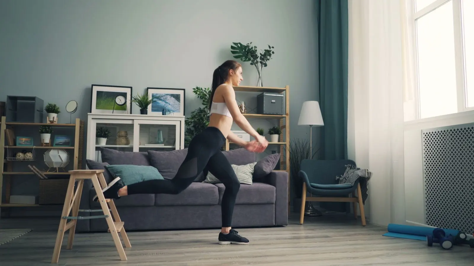 Woman performing a supported low-impact leg exercise at home